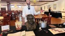 Auctioneer Jonathan Klunk gestures to a display of personal items