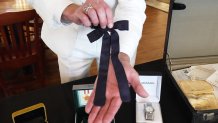 Auctioneer Jonathan Klunk shows a black bow tie worn by KFC founder