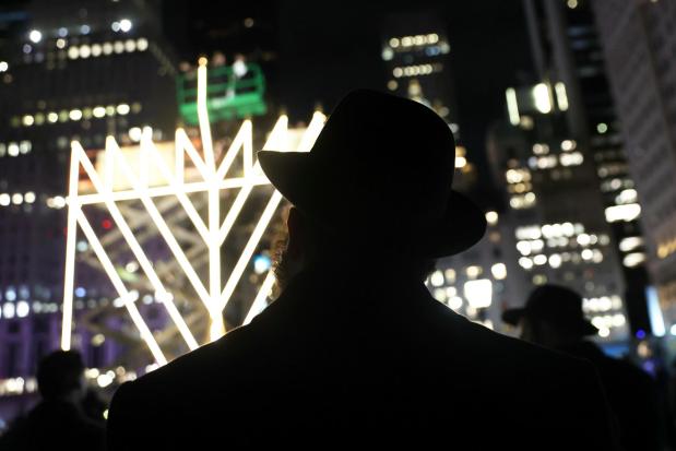 People watch the lighting of the world's largest menorah on Fifth Avenue by Central Park.