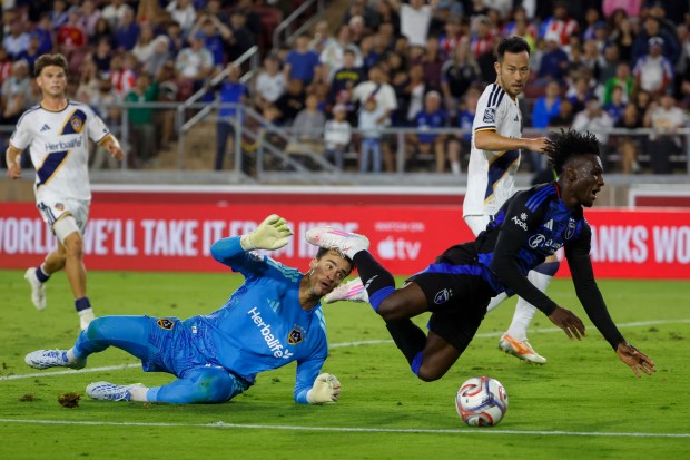 San Jose Earthquakes' Ousseni Bouda (7) falls with the ball against LA Galaxy's goalkeeper JT Marcinkowski (12) in the second half at Stanford Stadium in Stanford, Calif., on Saturday, July 25, 2026.  (Shae Hammond/Bay Area News Group)