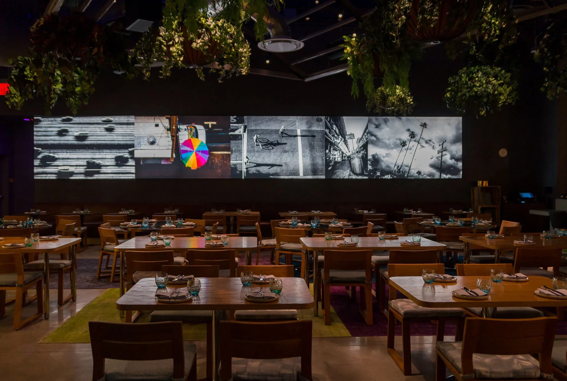 Dining room at Best Friend in Vegas with greenery overhead and dim lighting.