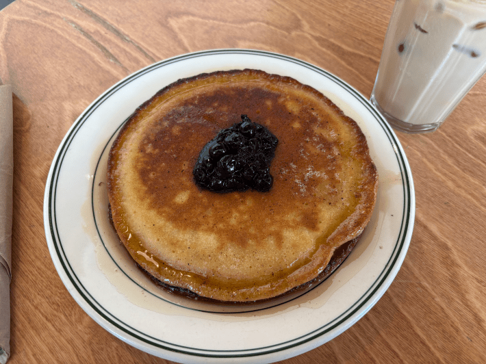 A stack of two pancakes topped with a blueberry compote