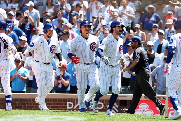 Cubs Michael Conforto, from left, Miguel Amaya and Dansby Swanson celebrate at home plate after Sawnson's three-run home run in the third inning against the Padres at Wrigley Field on July 1, 2026. (Terrence Antonio James/Chicago Tribune)