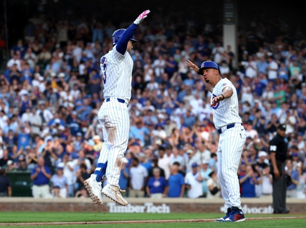Chicago Cubs third baseman Alex Bregman (left) celebrates with third base coach Quintin Berry after Bregman hit a three-run home run in the second inning of a game against the San Diego Padres at Wrigley Field in Chicago on June 30, 2026. (Chris Sweda/Chicago Tribune)