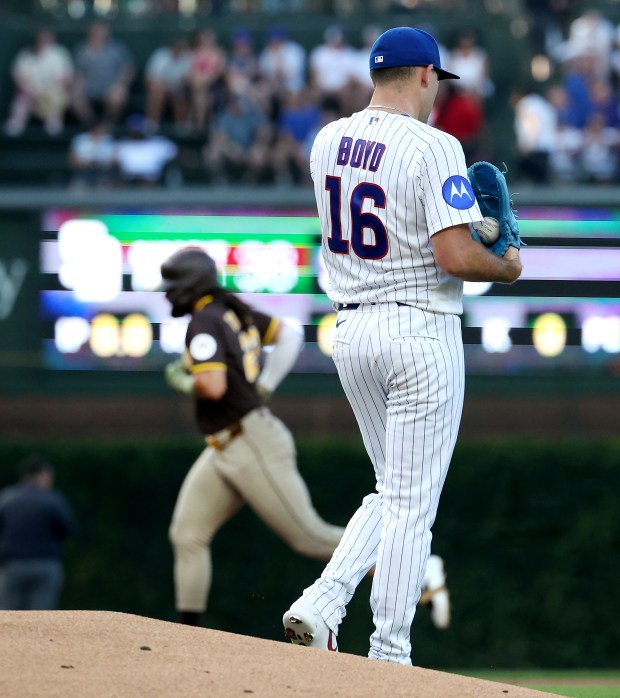 Chicago Cubs starting pitcher Matthew Boyd (16) walks off the mound as San Diego Padres right fielder Fernando Tatis Jr. (background) rounds the bases after hitting a solo home run in the first inning of a game at Wrigley Field in Chicago on June 30, 2026. (Chris Sweda/Chicago Tribune)