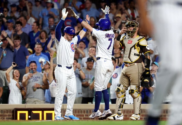 Chicago Cubs shortstop Dansby Swanson (7) is congratulated by teammate Ian Happ (left) after Swanson hit a two-run home run in the fifth inning of a game against the San Diego Padres at Wrigley Field in Chicago on June 30, 2026. (Chris Sweda/Chicago Tribune)