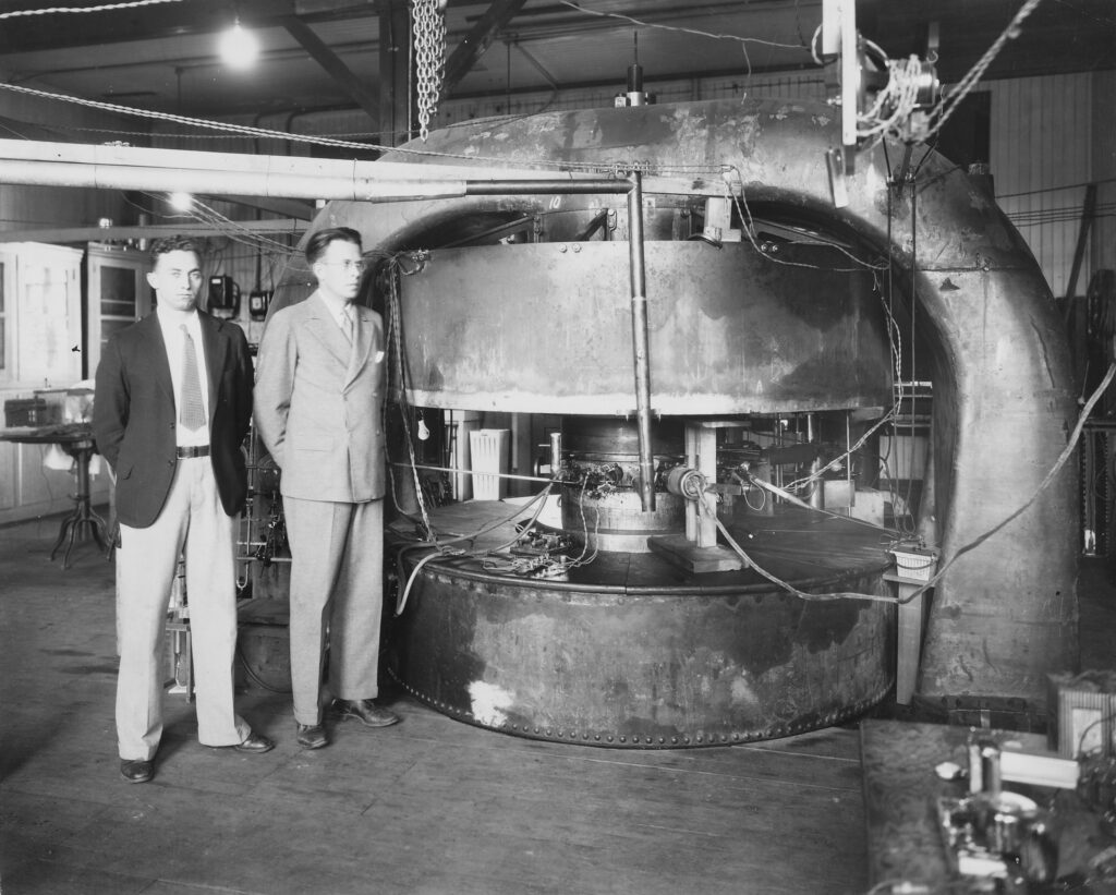 M. Stanley Livingston (L) and Ernest O. Lawrence in front of 27-inch cyclotron at the old Radiation Laboratory at UC Berkeley, circa 1934