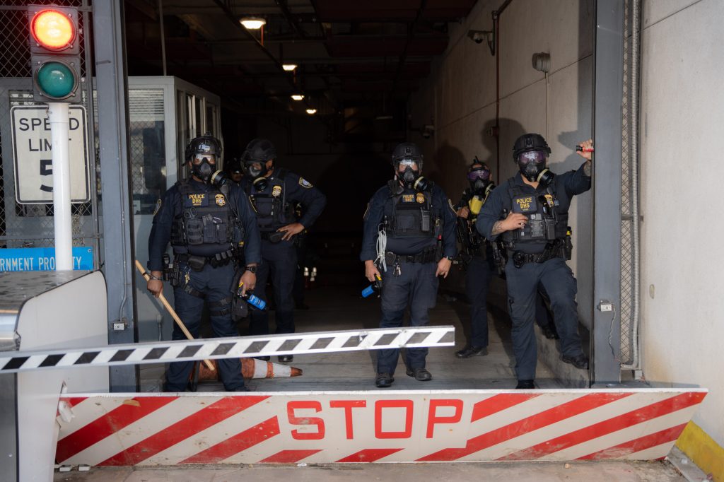 Department of Homeland Security agents guard an entrance to Los Angeles’ Metropolitan Detention Center during a protest in June 2025. Photo: Jeremy Lindenfeld for Capital & Main.