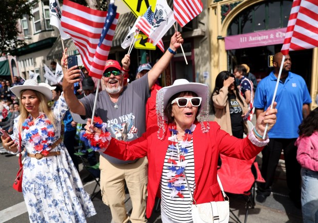 Tatiana Metushi, right, along with her husband Tim and daughter Albena, to the left, of San Leandro, watch the Alameda 4th of July Parade head down Park Street in Alameda, Calif., on Saturday, July 4, 2026. (Jane Tyska/Bay Area News Group)