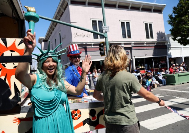 Erika Benitez And Evan Phillippe, from left, of the Pacific Pinball Museum, ride on their float along Park Street during the Alameda 4th of July Parade in Alameda, Calif., on Saturday, July 4, 2026. (Jane Tyska/Bay Area News Group)