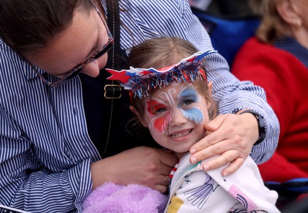 Anna Malkova, 4, is comforted by her mom Katerina, of Alameda, as the noisy Alameda 4th of July Parade heads down Park Street in Alameda, Calif., on Saturday, July 4, 2026. (Jane Tyska/Bay Area News Group)
