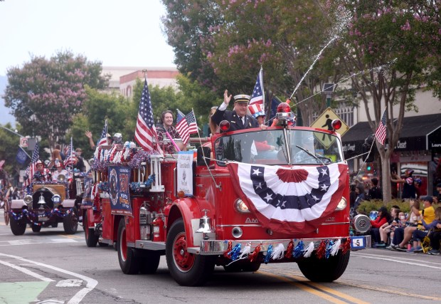 Alameda Fire Department Chief Nick Luby waves to the crowd from a vintage firetruck as the Alameda 4th of July Parade heads down Park Street in Alameda, Calif., on Saturday, July 4, 2026. (Jane Tyska/Bay Area News Group)