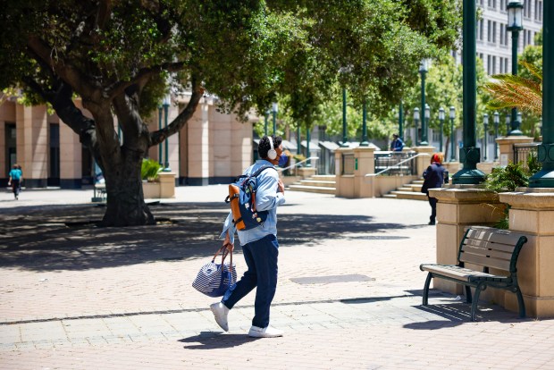 A person walks near city hall in downtown Oakland, Calif., on Friday, May 23, 2025. (Shae Hammond/Bay Area News Group)