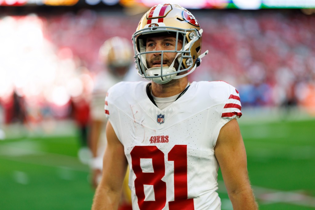 A San Francisco 49ers player in a white and red jersey with number 81 and a gold helmet.