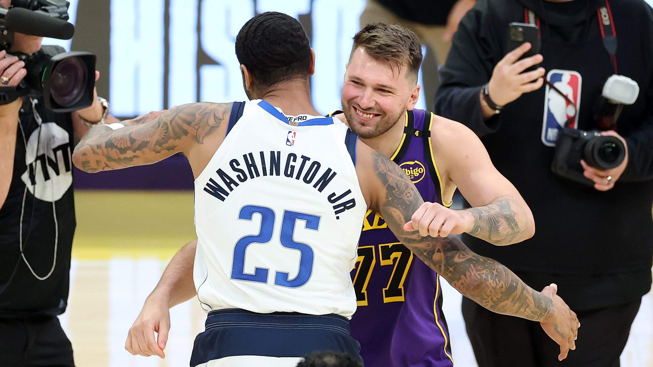 Dallas Mavericks forward P.J. Washington embraces Luka Dončić after an NBA game.