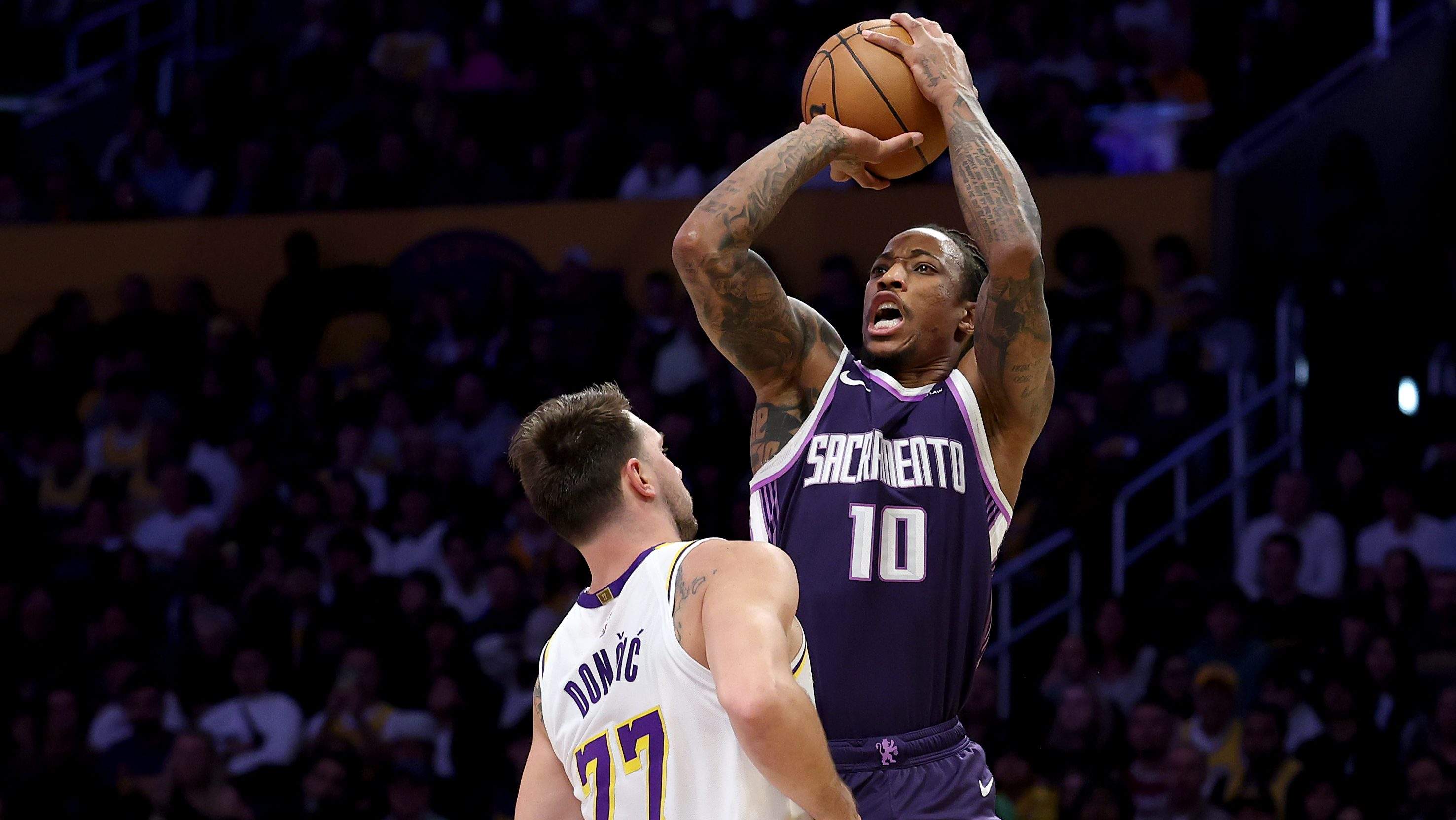 DeMar DeRozan shoots over Luka Dončić during a Sacramento Kings vs. Los Angeles Lakers NBA game.