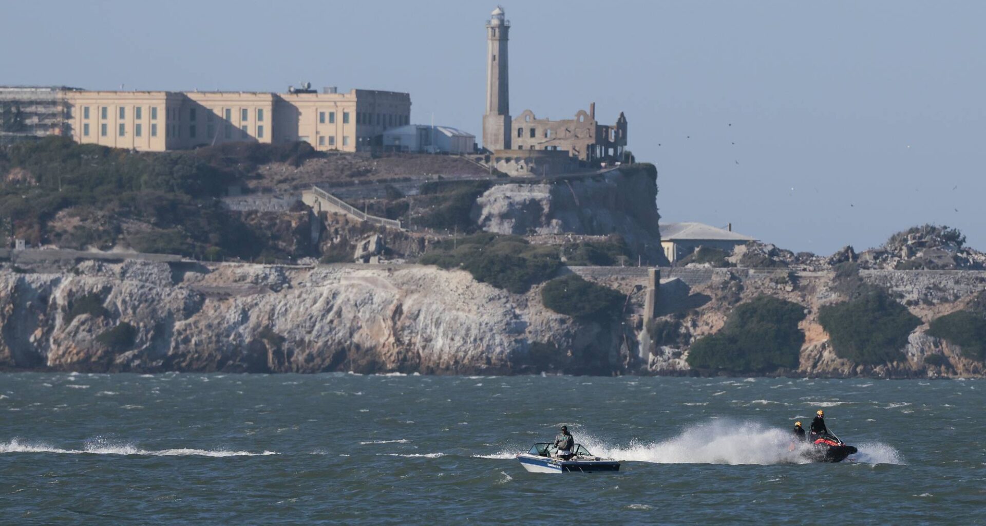 A jet ski and a boat off the coast of an island