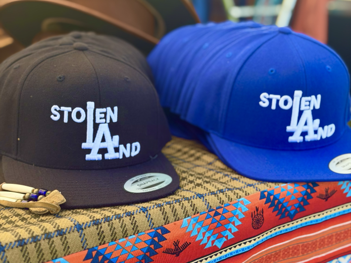 hats that say "Stolen LAnd" using the L.A. Dodgers logo