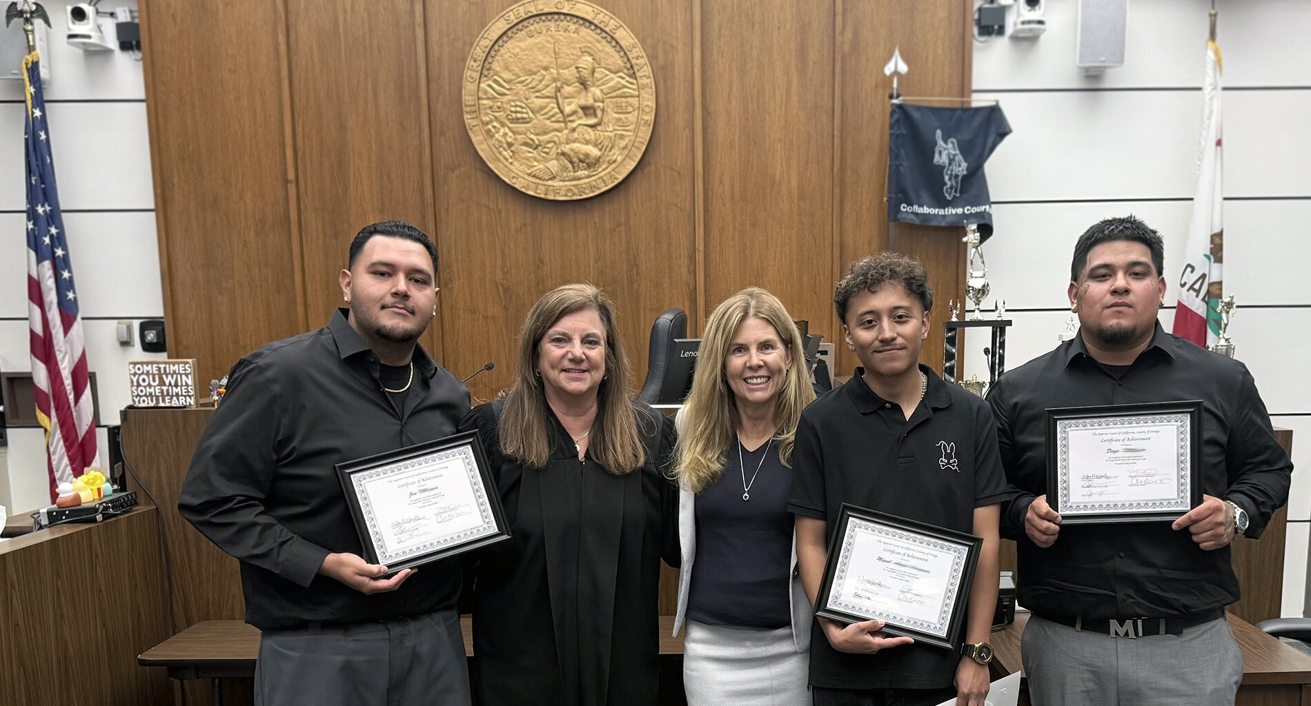 Judge and professor pose with three graduates in courthouse