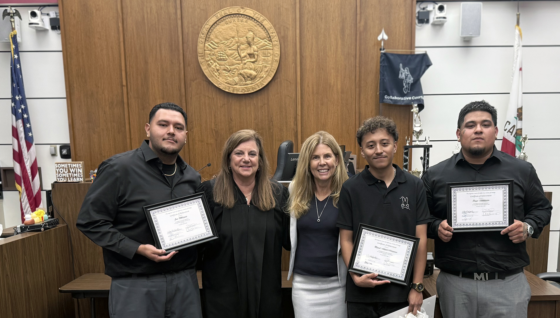 Judge and professor pose with three graduates in courthouse