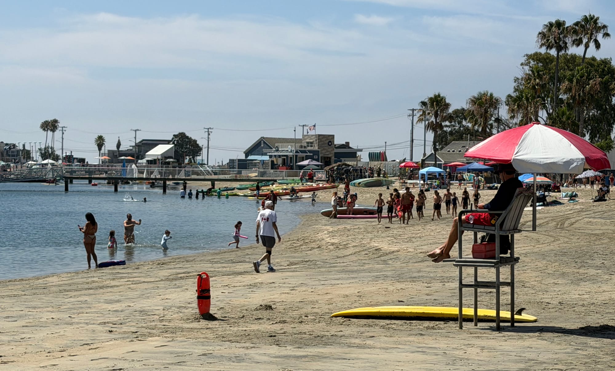 People walk along the beach on a sunny day.