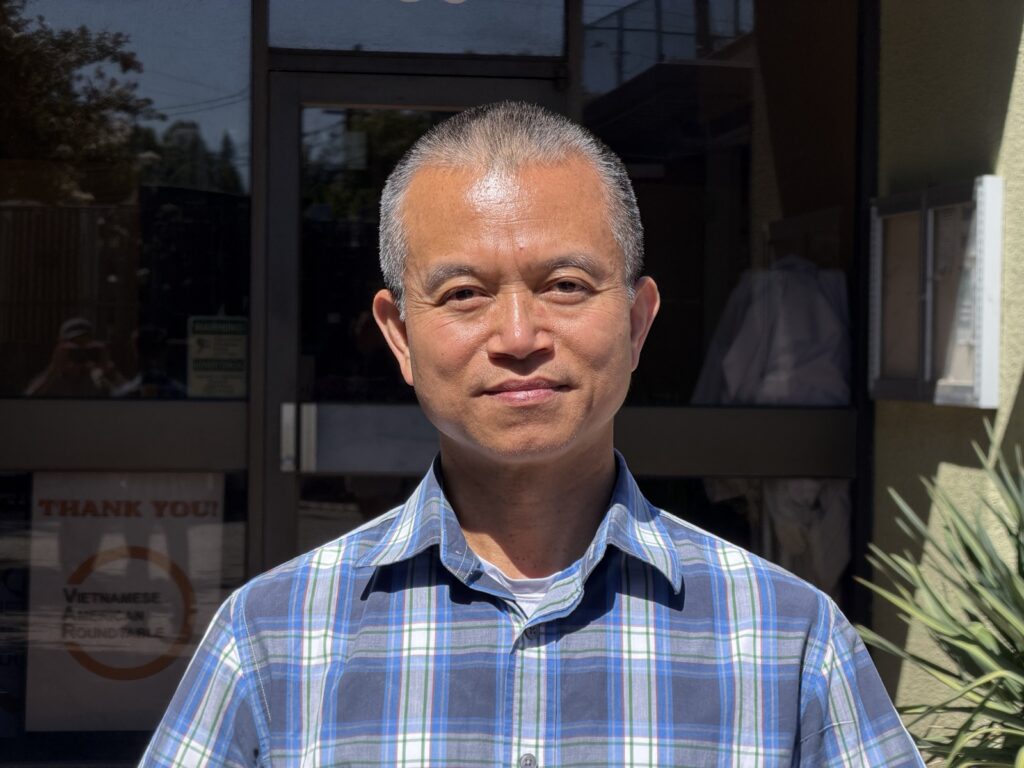A man stands in front of a glass door.