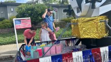 Briede Charbonnet, and two of his children put finishing touches on their homemade float, Saturday, La Jolla, Calif., July 4, 2026.