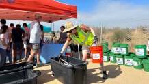 Volunteers were given safety equipment before they began clean up on Fiesta Island, San Diego, Calif., July 5, 2026.