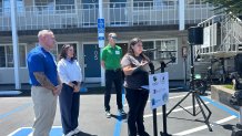 Ollie (standing at the podium) talked about her life being unhoused, during a news conference, Thursday, at the HaborTAY House, July 23, 2026.