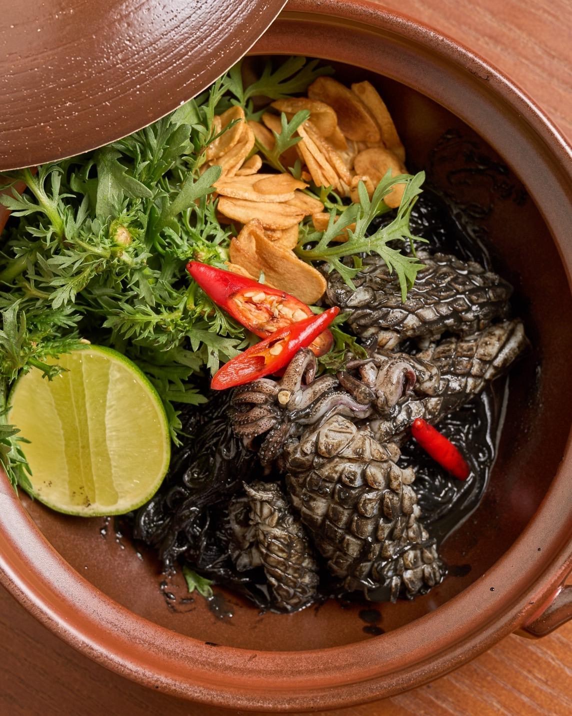 A claypot with squid, herbs, Thai chiles, and a lime half from Saam in San Francisco.