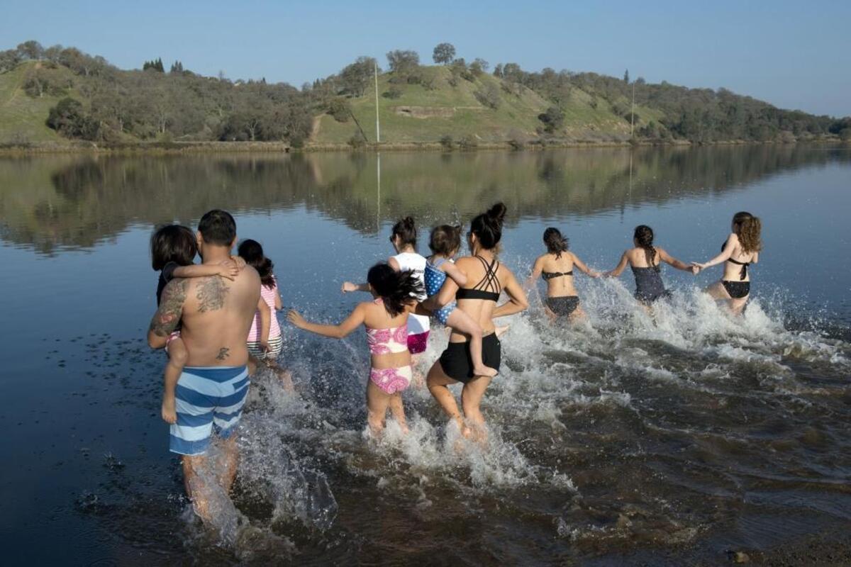 A group of family and friends from Roseville enter Lake Natoma for the Polar Bear Plunge on Jan. 1, 2015.
