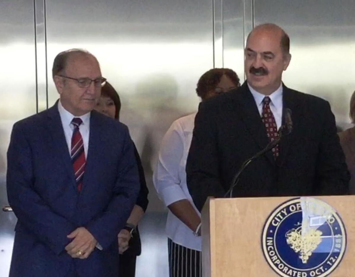 Newly hired Fresno police auditor John Gliatta, right, talks to reporters after he was introduced Wednesday by Mayor Lee Brand, left, in August 2017.