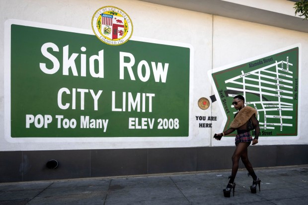 A person walks past the 6th Street Place apartments where the Skid Row City Limit Mural was repainted after the supportive housing complex with 93 units was built at the corner of San Julian and 6th streets in Skid Row. (Photo by Sarah Reingewirtz, Los Angeles Daily News/SCNG)