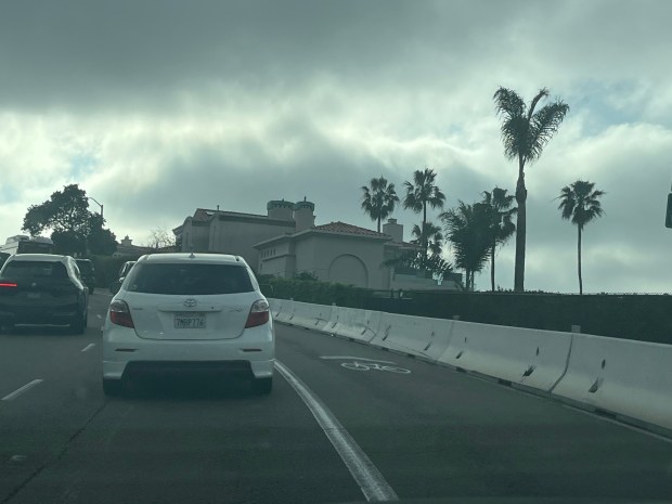 A temporary K-rail barrier remains along Torrey Pines Road in La Jolla until a permanent replacement guardrail is installed. (Noah Lyons)