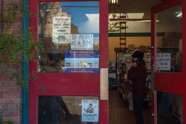 The entryway to a business includes several signs, one of which says "Save Hopkins"