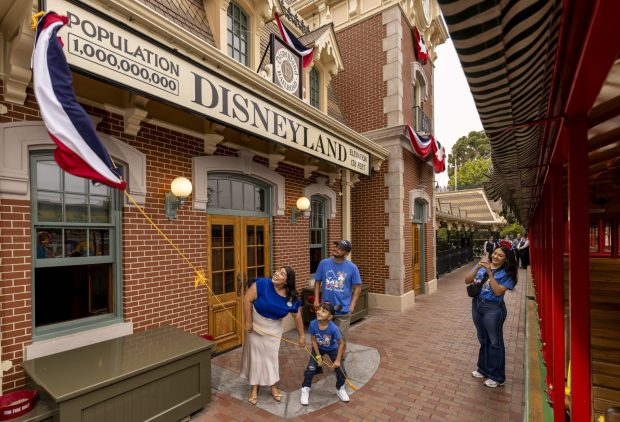 Andres Robles, 8, of Arizona, helps unveil the new population sign on the Disneyland train station. (Courtesy of Disneyland)