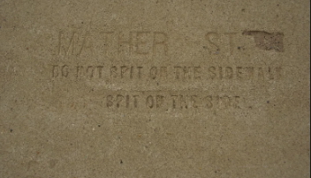 The faded words on this Marquette sidewalk are among the last traces of an era when tuberculosis was one of the nation's deadliest diseases and cities enlisted pedestrians in the fight against it. (Courtesy Marquette Regional History Center)