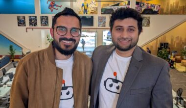 two men wearing logo tshirts and jackets