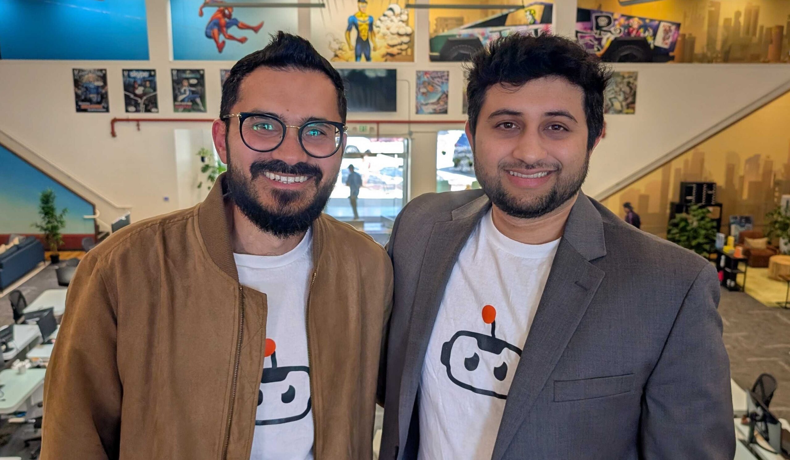 two men wearing logo tshirts and jackets