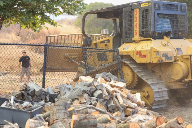 Homeowner Randy Waitman watches as a CalFire dozer breaks through his gate and fence in order to create a fire break near his home during the Creelman fire in Ramona on July 22, 2026. (Stephanie Ogilvie)