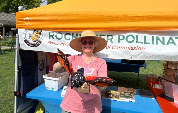 Volunteer Michelle Berry Lane welcomes visitors at a Rochester Pollinators event. Through native plant sales, educational programs and community outreach, the organization encourages residents to create pollinator-friendly habitats in their own yards. (Courtesy of Rochester Pollinators)