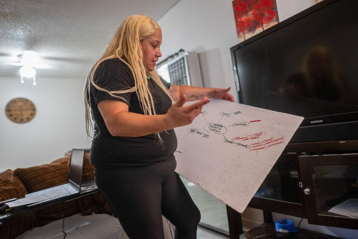 Jocelyn Wright holds a chart she created to better understand the county system as she seeks assistance to continue working and maintain her apartment in Rancho Cordova on June 9.