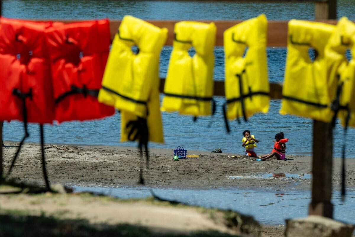 Achilles Dixon, 4, left, and Tuwa Dixon, 7, right, both of Sacramento, wear life jackets at Tiscornia Beach on July 3. The park provides free life jackets for children.
