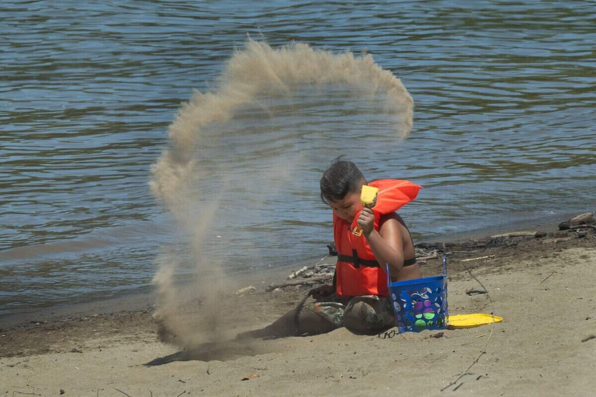 Claudio Garcia, 6, of Sacramento wears a life jacket while playing in the sand at Sacramento's Tiscornia Beach along the American River on Friday, July 3. The park provides free life jackets for children.