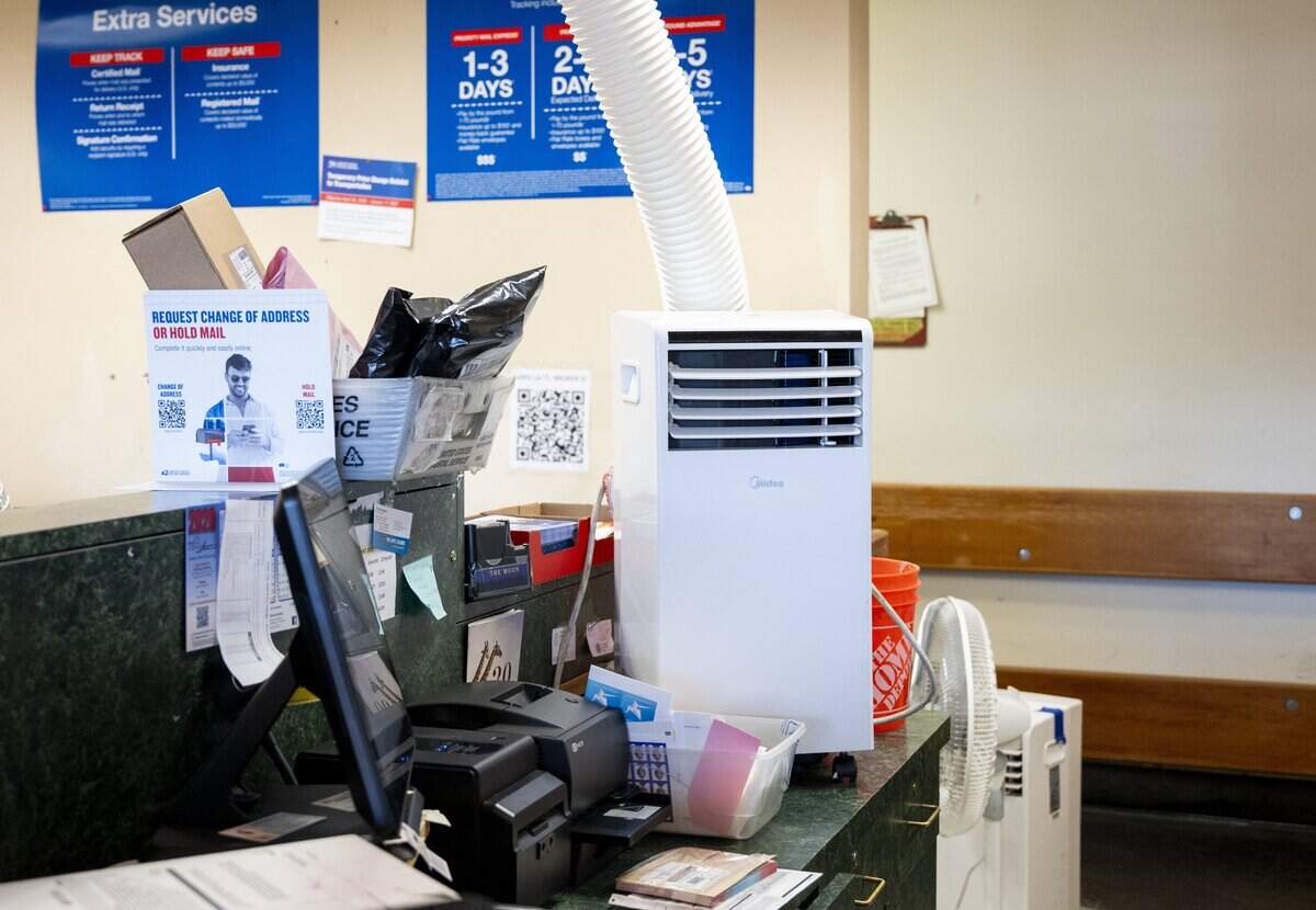 A portable air conditioning unit sits on a clerk's desk at the Centre Branch Post Office on El Camino Avenue in Sacramento on July 16, 2026.