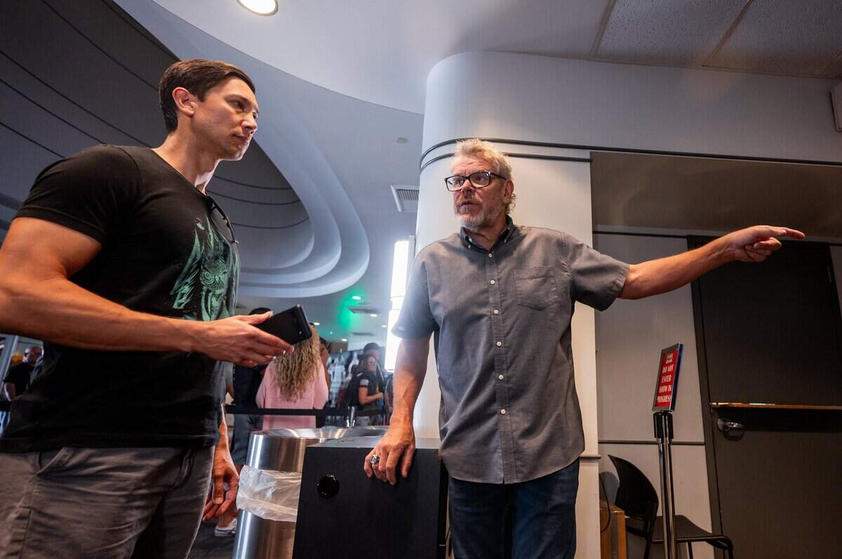 Theater director Doug Link, right, helps an audience member check in before the screening of Christopher Nolan’s new movie “The Odyssey” at the Esquire IMAX Theatre in Sacramento on Friday, July 17, 2026.