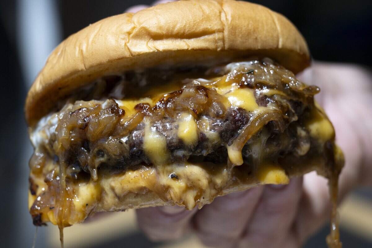 Chef Mike Fagnoni holds the Double Juicy Burger at Moksa Barrel House in Roseville on July 9. The casual quick-serve restaurant is also a collaboration with Moksa Brewing Company.