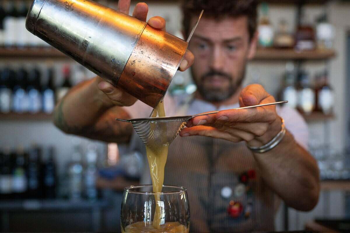 Bartender Leon Moore prepares a gold rush cocktail at Husick's by Forester restaurant in Clarksburg on July 23.