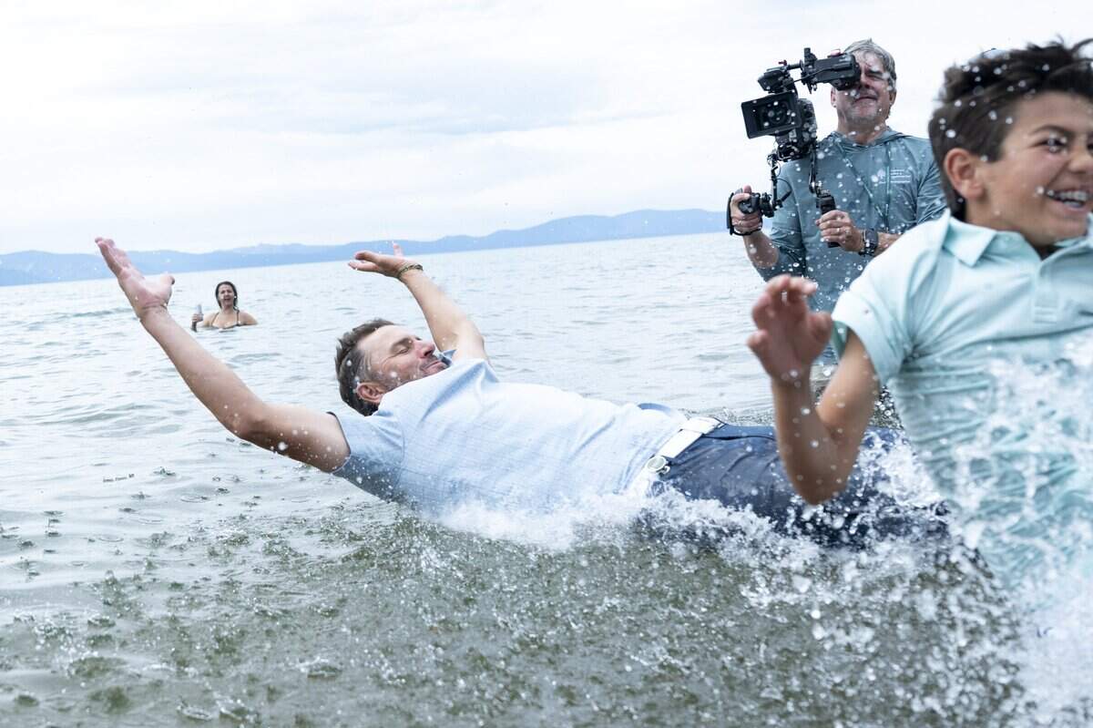 Former professional tennis player Mardy Fish jumps in Lake Tahoe with his son Beckett after winning the American Century Golf Tournament in Stateline, Nev., on Sunday.