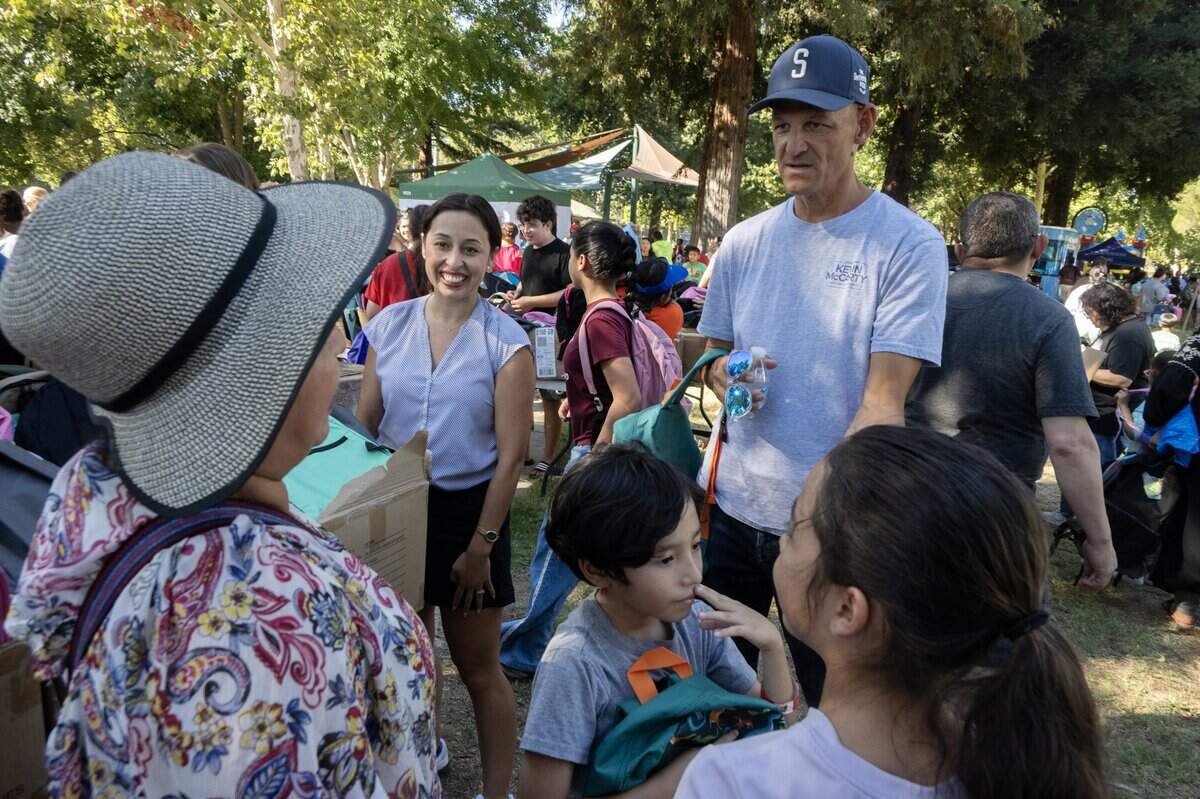 Sacramento Mayor Kevin McCarty and City Councilmember Karina Talamantes talk with backpack recipients during a backpack giveaway at Northgate Park on Wednesday.
